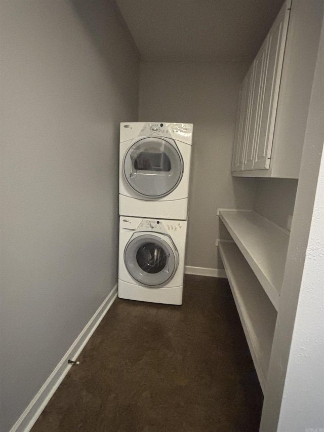 laundry room featuring laundry area, stacked washer and clothes dryer, and baseboards