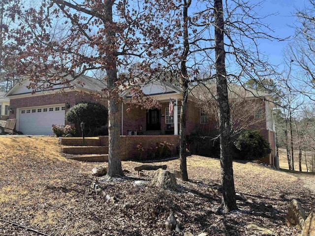 view of front of property with a garage, brick siding, and a porch