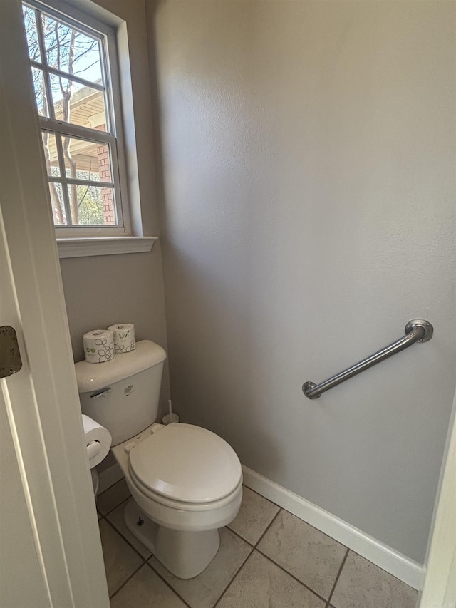 bathroom featuring baseboards, toilet, and tile patterned flooring