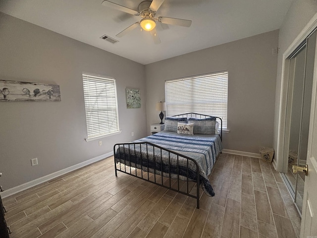 bedroom with visible vents, baseboards, and wood finished floors