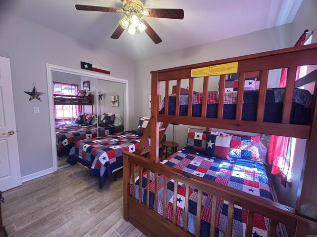 bedroom featuring a closet, baseboards, a ceiling fan, and wood finished floors