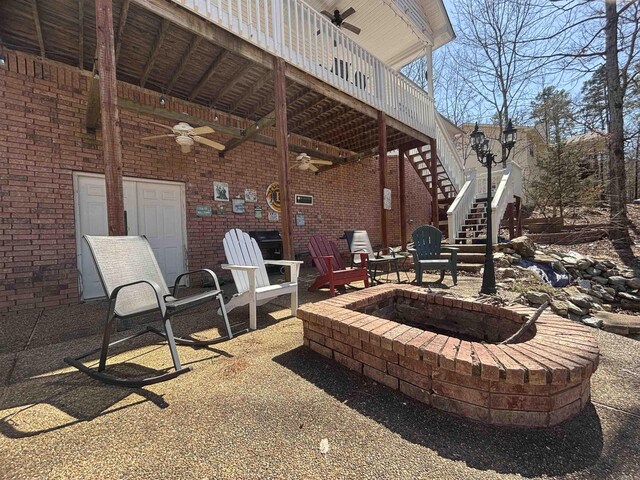 view of patio featuring stairway, a fire pit, and a ceiling fan