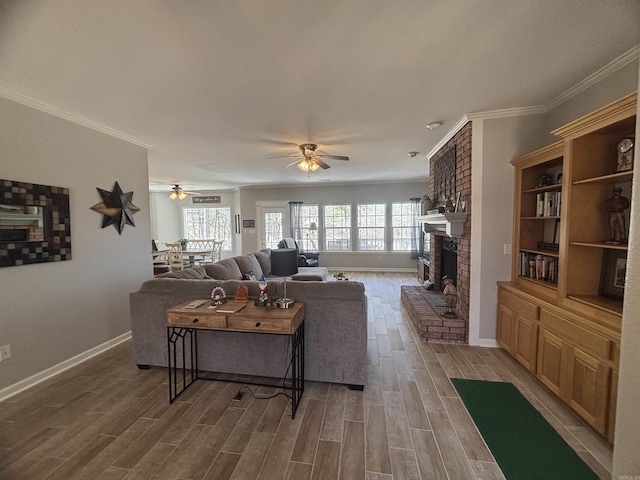 living area with a fireplace, a healthy amount of sunlight, and wood finish floors