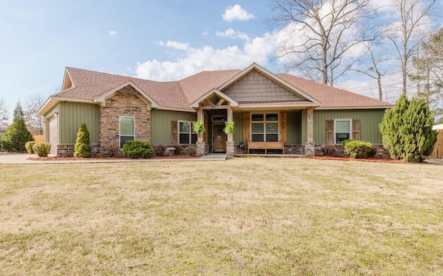 craftsman-style home with board and batten siding, a front lawn, stone siding, and roof with shingles