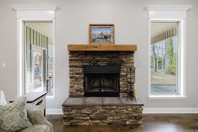 interior space featuring a stone fireplace, wood finished floors, and baseboards