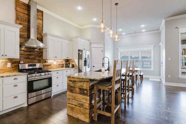 kitchen featuring a sink, dark wood-type flooring, appliances with stainless steel finishes, wall chimney range hood, and backsplash