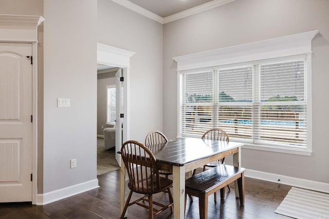 dining room featuring dark wood finished floors, crown molding, and baseboards