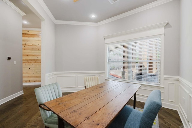 dining room featuring crown molding, dark wood-type flooring, a wainscoted wall, recessed lighting, and a decorative wall