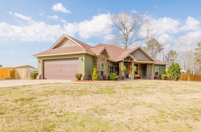 view of front of house featuring a front yard, fence, an attached garage, concrete driveway, and stone siding