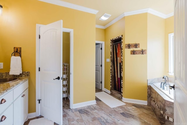 full bathroom featuring baseboards, vanity, a garden tub, and ornamental molding