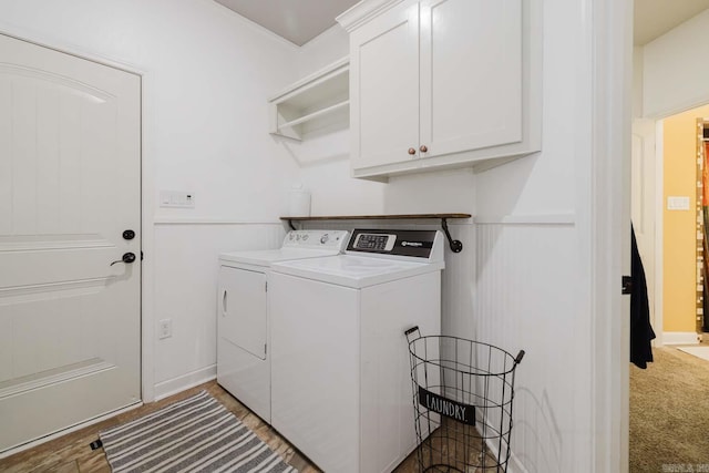 laundry room with cabinet space, light carpet, and washer and clothes dryer