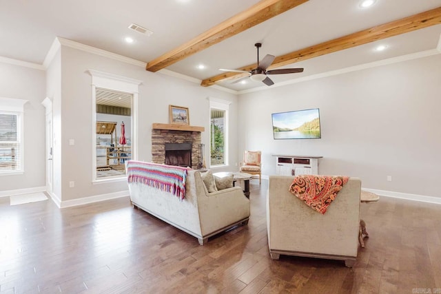 living room featuring beamed ceiling, baseboards, visible vents, and wood finished floors