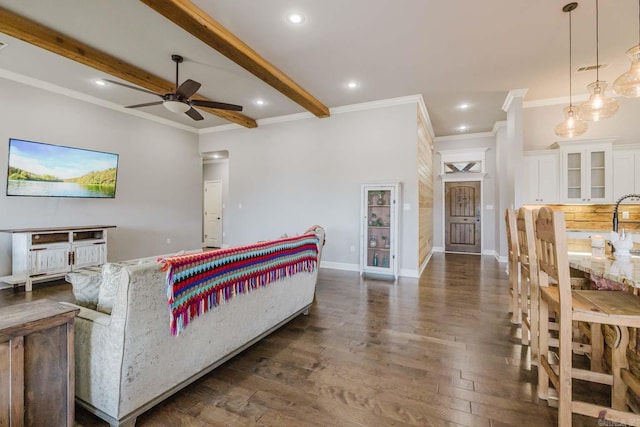 living area with baseboards, beam ceiling, dark wood-style floors, and crown molding