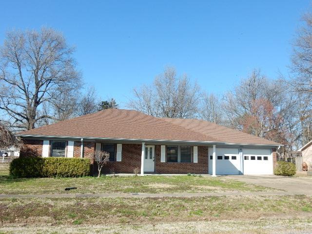 ranch-style house with a front lawn, a garage, brick siding, and driveway