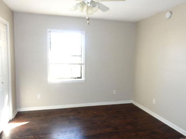 empty room featuring a ceiling fan, baseboards, and wood finished floors