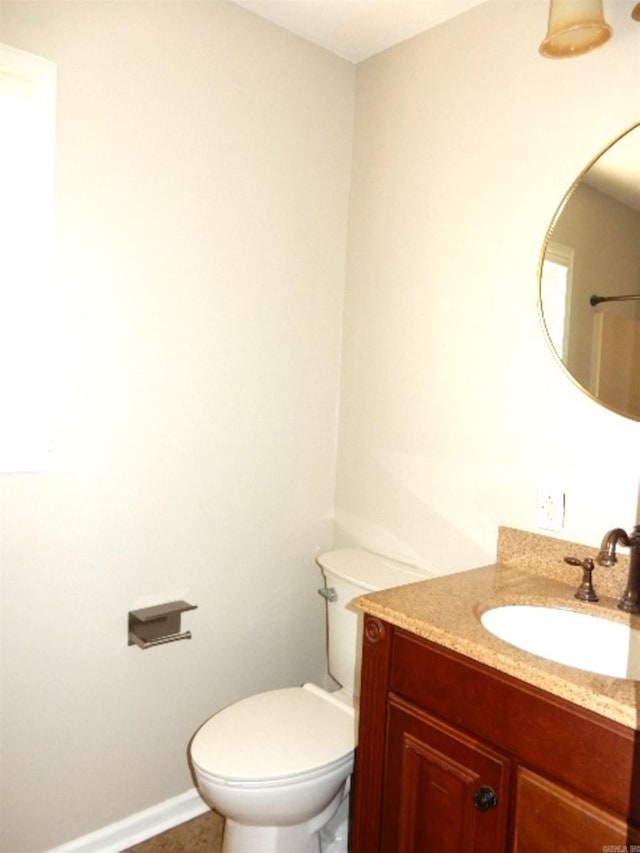 bathroom with vanity, toilet, and baseboards