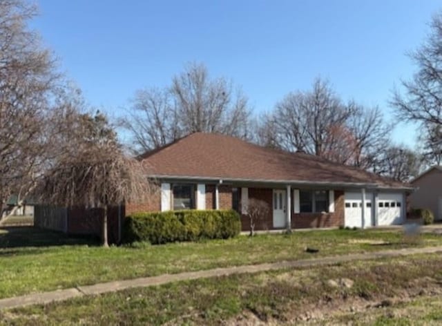 ranch-style home featuring an attached garage and a front lawn