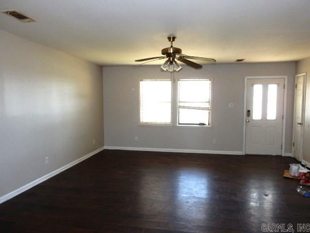 entrance foyer with visible vents, baseboards, a healthy amount of sunlight, and wood finished floors