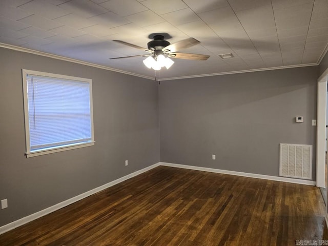 spare room with baseboards, dark wood-style floors, visible vents, and ornamental molding