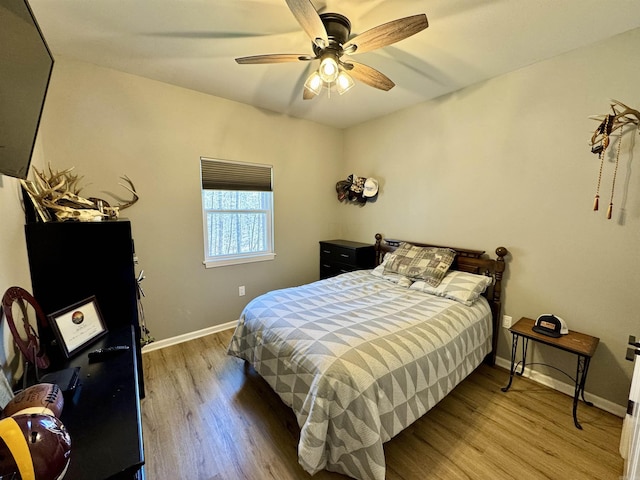 bedroom with a ceiling fan, baseboards, and wood finished floors