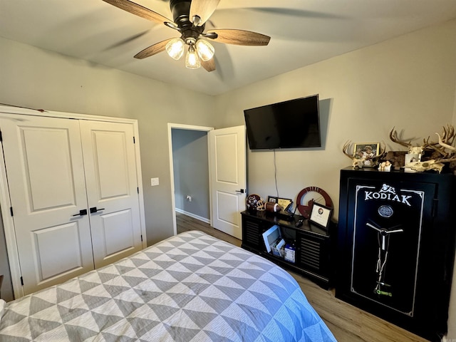 bedroom with a closet, wood finished floors, and a ceiling fan