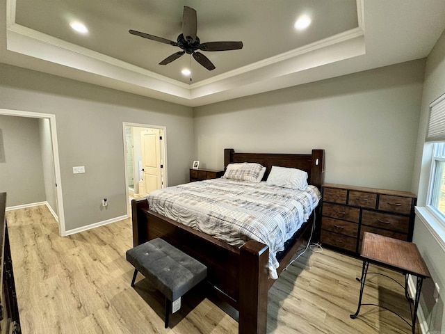 bedroom with a raised ceiling, light wood-style flooring, recessed lighting, and baseboards