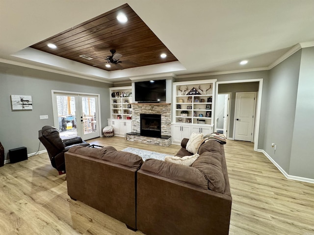 living area with french doors, a raised ceiling, wooden ceiling, and crown molding