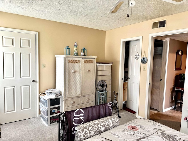 bedroom with visible vents, baseboards, carpet, and a textured ceiling