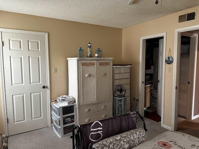 carpeted bedroom with visible vents and a textured ceiling