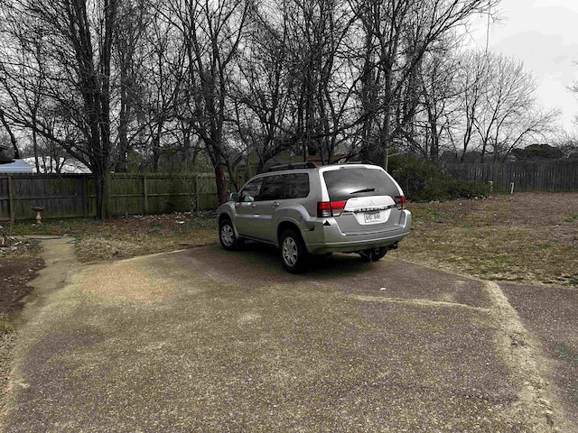 view of car parking featuring fence