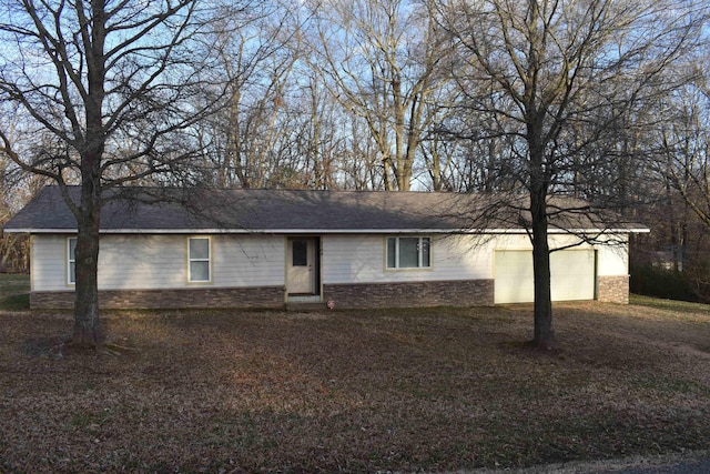 single story home featuring stone siding, driveway, and a garage