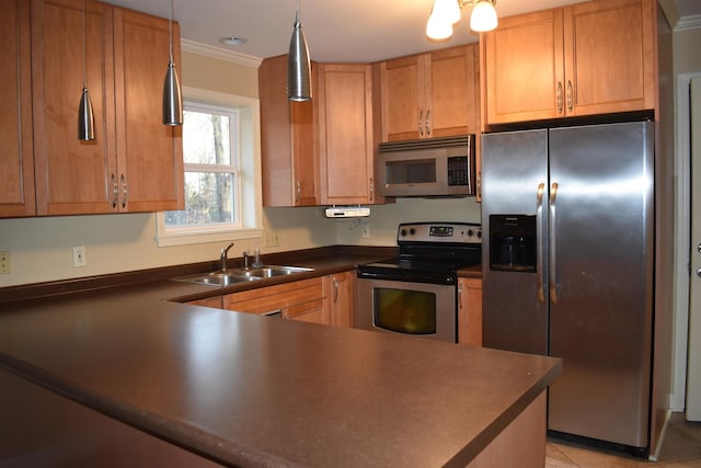 kitchen with dark countertops, crown molding, pendant lighting, stainless steel appliances, and a sink