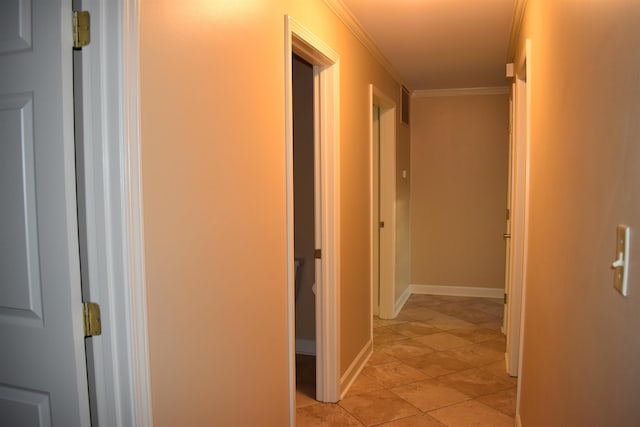 hall with visible vents, baseboards, and ornamental molding