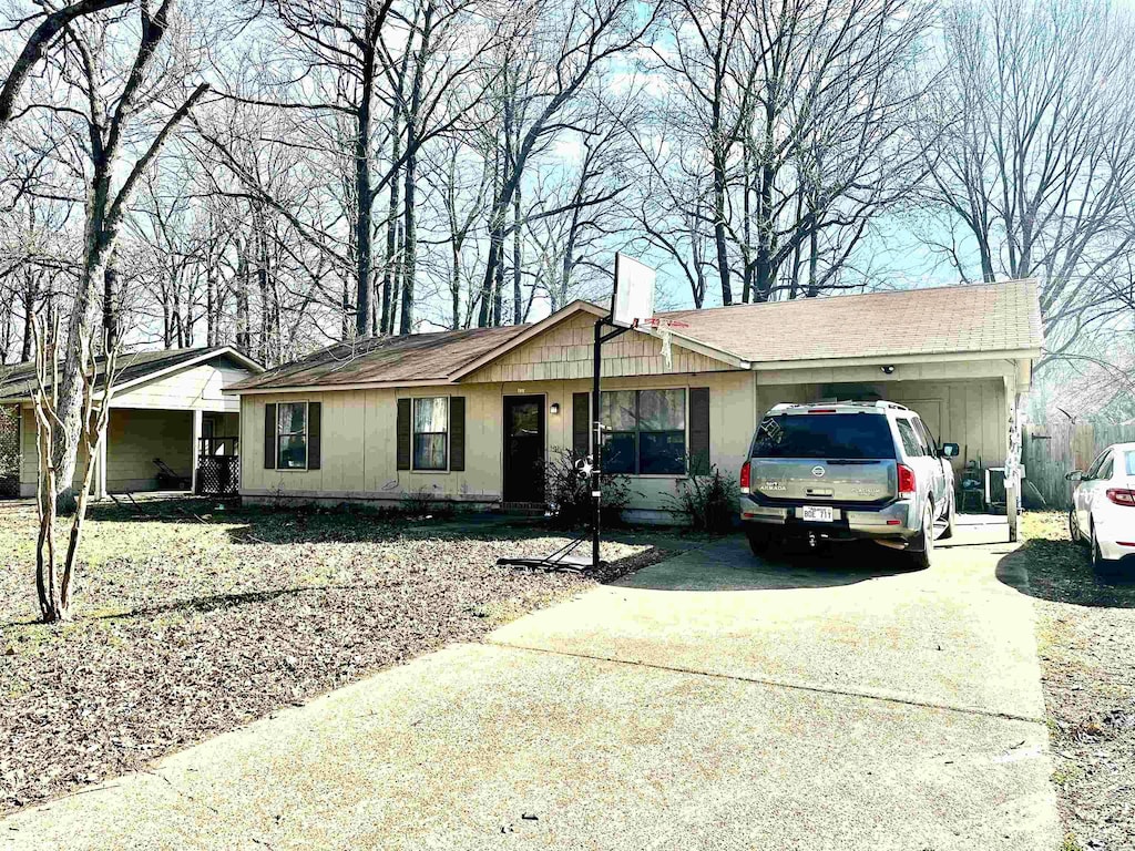 ranch-style home with an attached garage, driveway, and a chimney