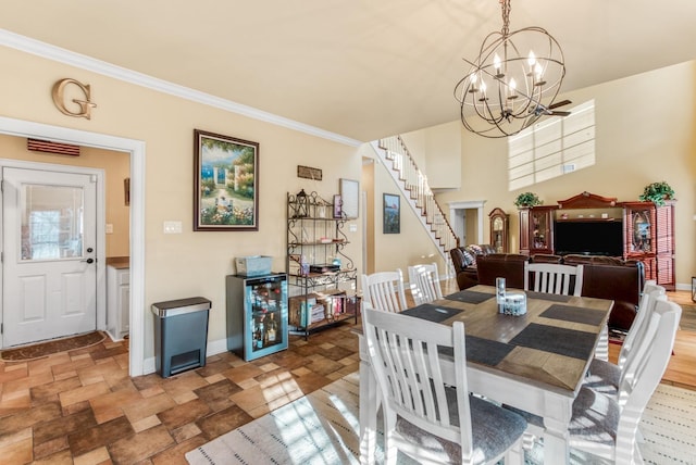 dining area featuring beverage cooler, a notable chandelier, stone finish floor, and stairs