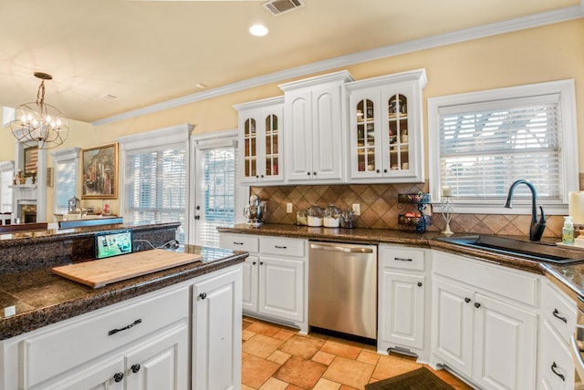 kitchen featuring dark countertops, visible vents, glass insert cabinets, dishwasher, and a sink