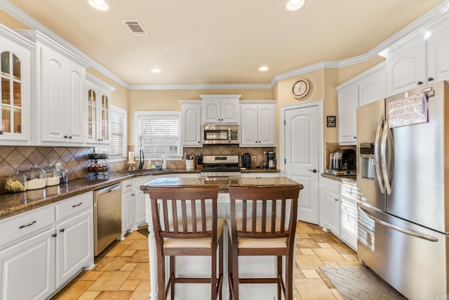 kitchen featuring stone tile floors, visible vents, stainless steel appliances, and a sink