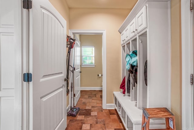 mudroom with stone finish floor and baseboards