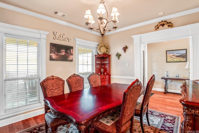 dining space featuring wood finished floors, visible vents, and ornamental molding