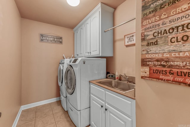 laundry room with baseboards, washing machine and dryer, light tile patterned floors, cabinet space, and a sink