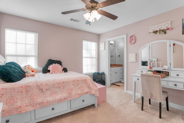 bedroom featuring visible vents, ceiling fan, baseboards, light carpet, and ensuite bathroom