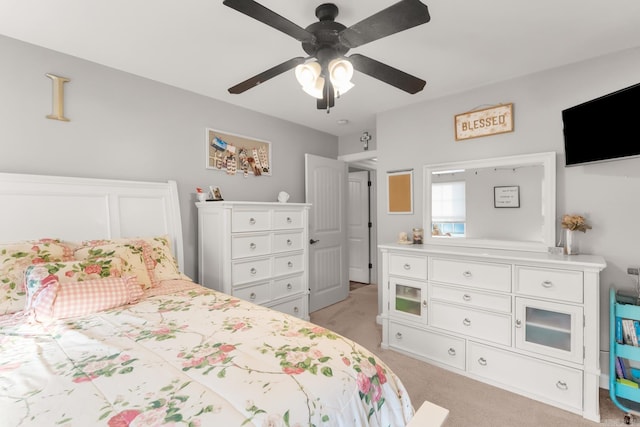 bedroom featuring light colored carpet and a ceiling fan