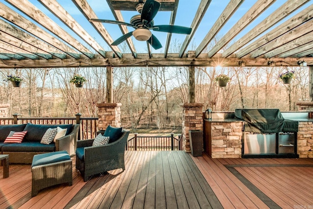 wooden terrace featuring exterior kitchen, an outdoor living space, and a pergola