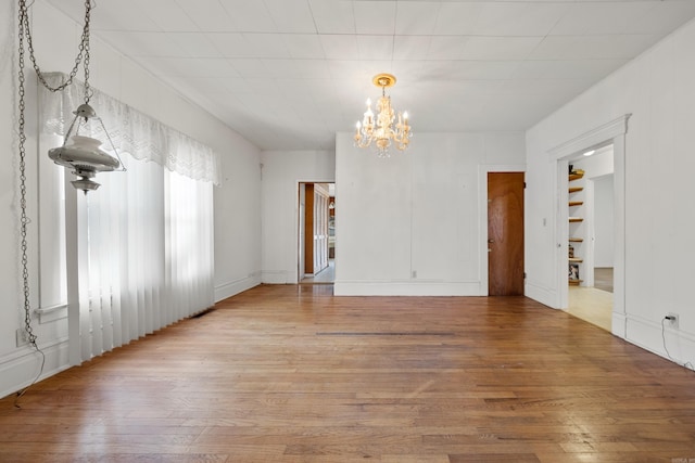 unfurnished dining area featuring light wood-type flooring and a chandelier