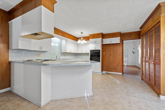 kitchen with black oven, light floors, light countertops, a peninsula, and white electric stovetop