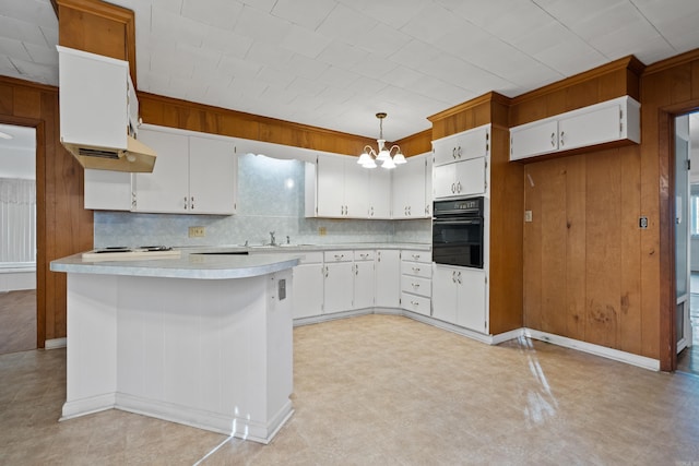 kitchen featuring a sink, oven, light countertops, white cabinetry, and tasteful backsplash