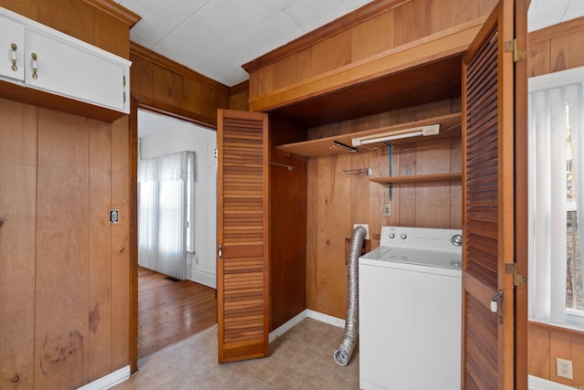 laundry area with laundry area, washer / dryer, light floors, and wooden walls