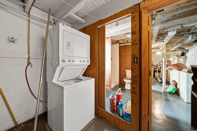 laundry room with stacked washer and dryer and laundry area