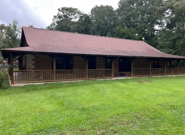 cabin featuring log siding and roof with shingles