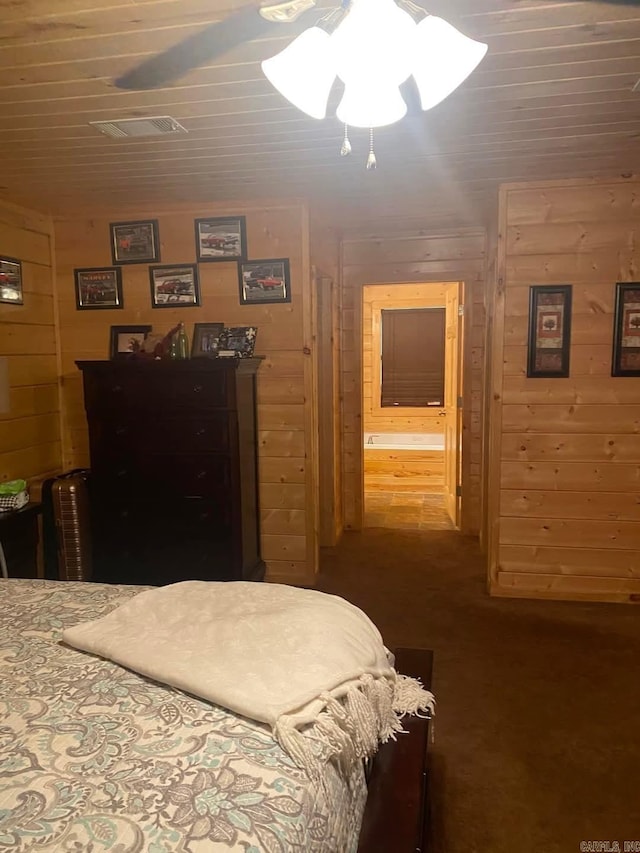 bedroom featuring visible vents, wooden walls, wood ceiling, and ensuite bath